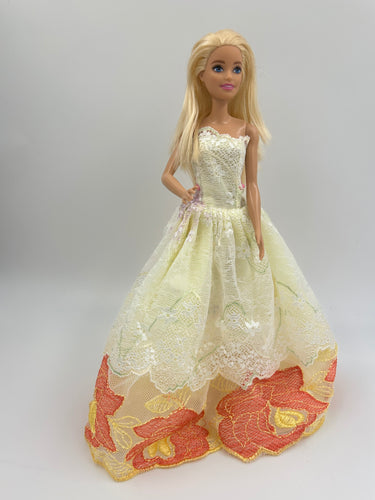 Elegant yellow strapless dress features a delicate lace overlay with floral 11 inch barbie dress